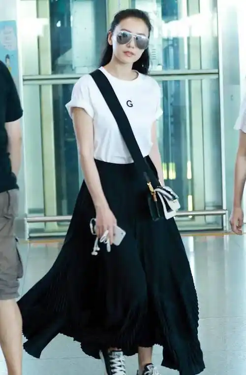 高圆圆一身白色t恤 黑色百褶裙,搭配帆布鞋,也是有不一样的感觉.