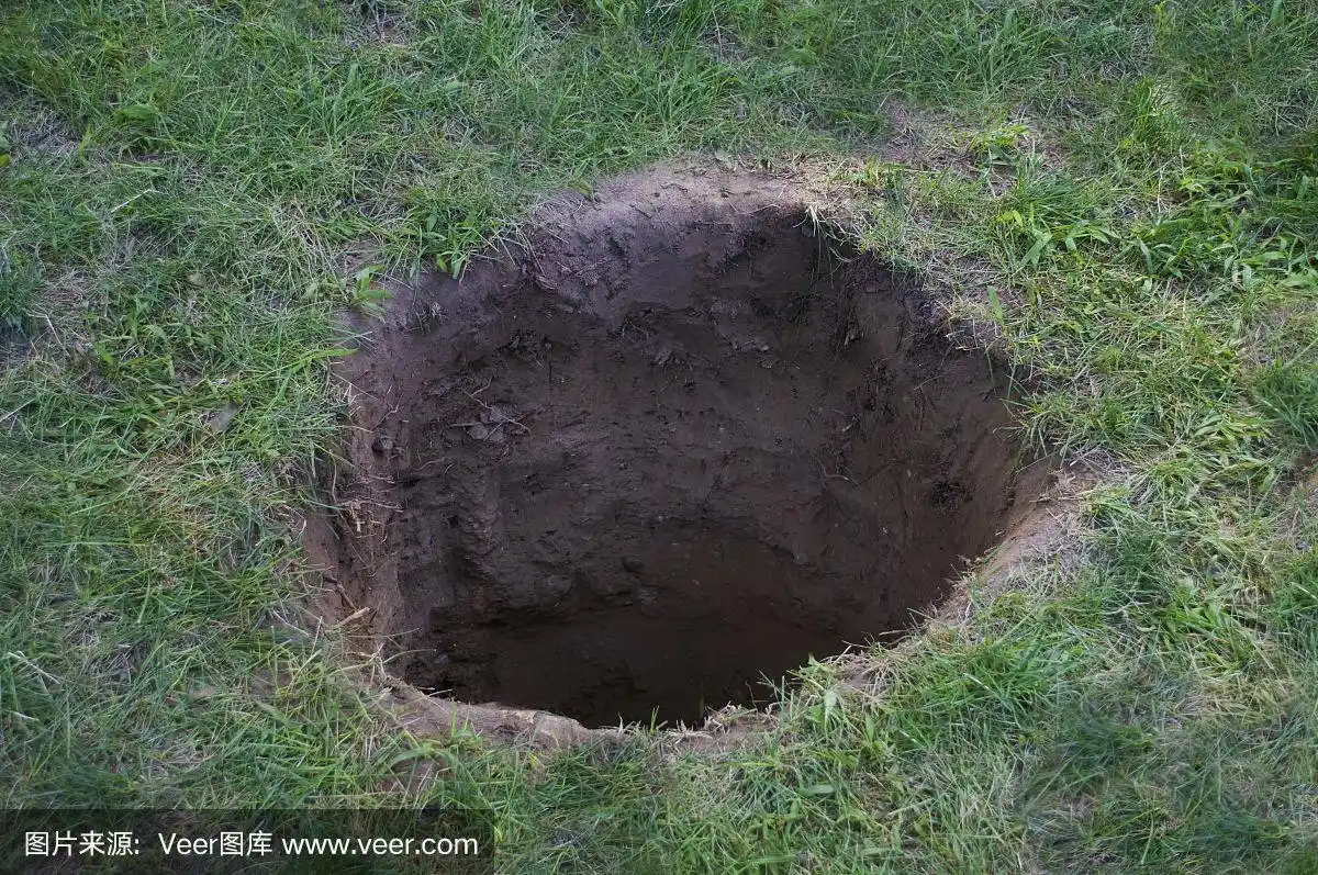 在地面或草坪上的深的泥洞