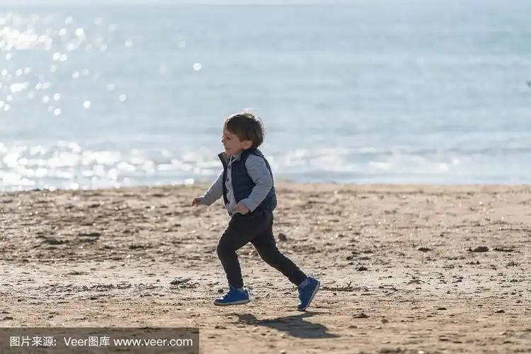 小男孩在海滩上跑步