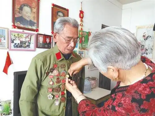 6月8日,小区举办红色教育活动,老伴王武英帮董安国穿上挂满军功章的