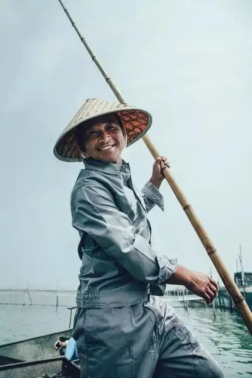 渔民露出朴实而真诚的笑容迎着湖面上升起的太阳各个生龙活虎捕捞上来