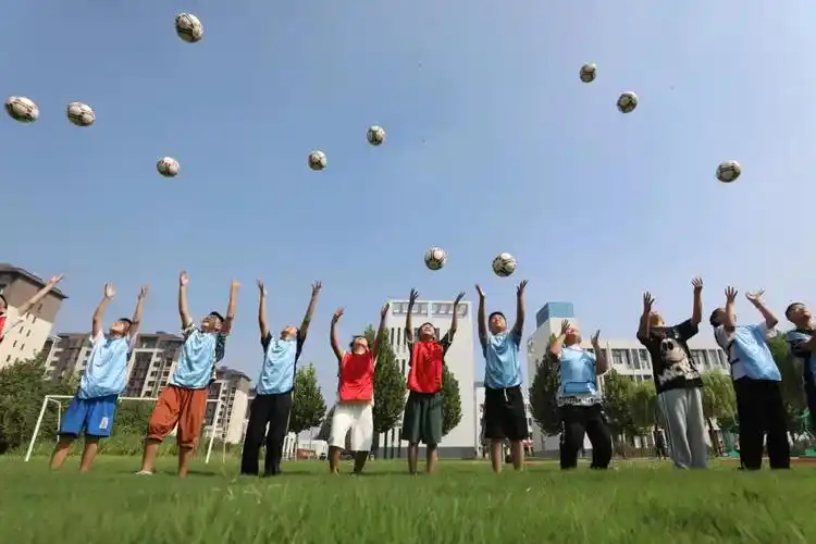 8月31日,河南省焦作市温县第四实验小学学生在体育课上学习足球技能.