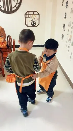 现在我们的小朋友们互相帮忙解围裙了 ,将面点服物归原处