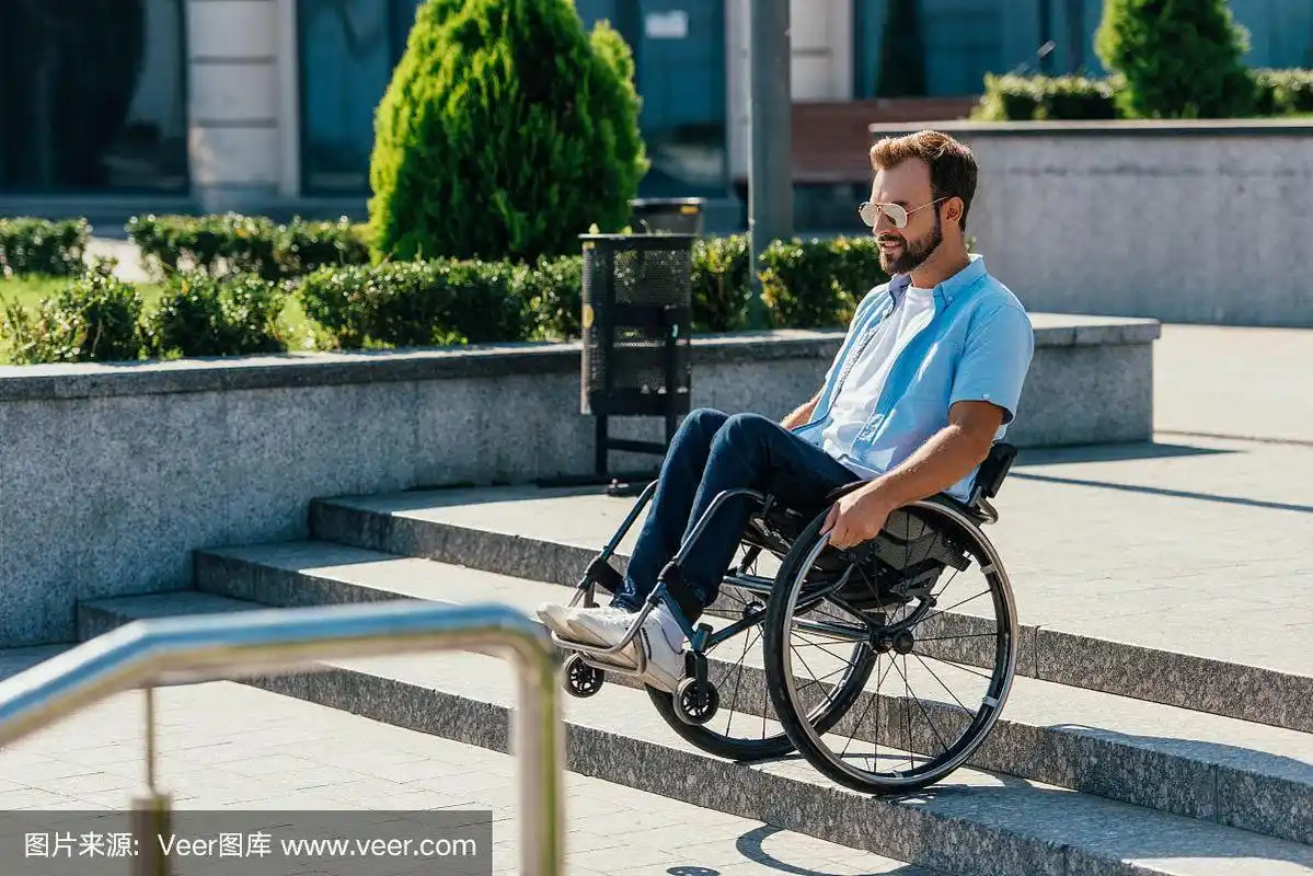 戴着墨镜坐轮椅的帅哥在没有坡道的楼梯上