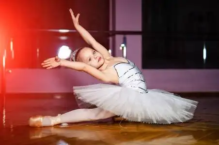 天才儿童一个穿着白色短裙的年轻芭蕾舞演员在舞厅里织麻线.舞蹈概念.