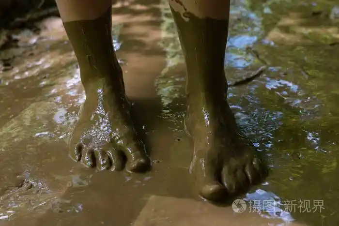 泥泞和肮脏的脚充满了泥走在泥泞的森林地板上