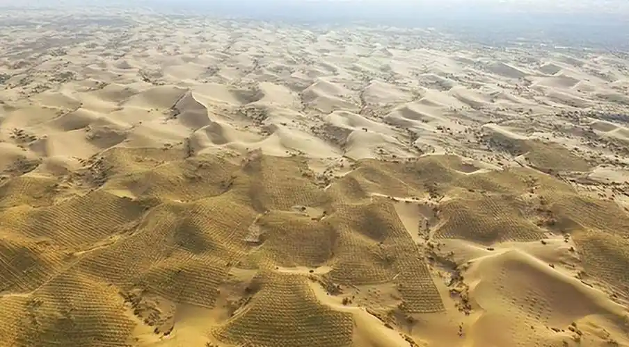 从高空俯瞰,以沙丘链和格状沙丘形态分布的库布齐沙漠在微风轻拂下