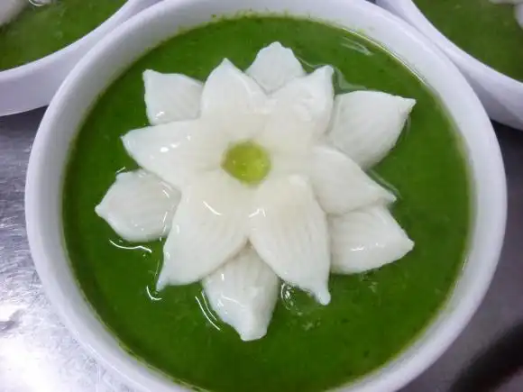 分入小碗中,入蒸笼蒸熟.把汆熟的鱼茸荷花放入小碗.