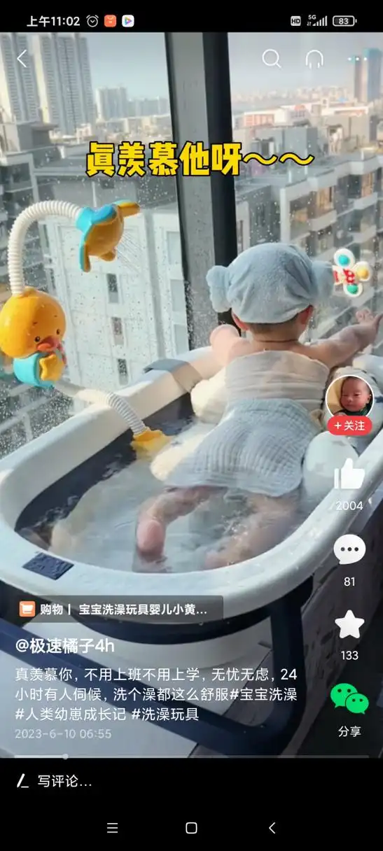 小宝宝舒服地躺在浴盆里,花洒均匀地喷出水花,小宝宝一边惬意地享受