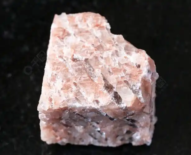 地质采集中天然矿物样品的特写镜头黑色花岗岩背景上的粗花岗岩伟晶岩