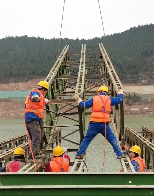 图为工人在进行钢栈桥铺设.