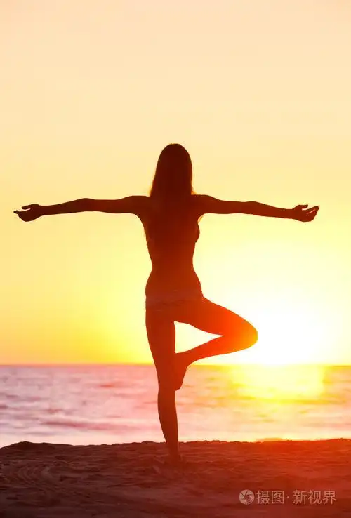 在日落的美丽瑜伽女人的剪影