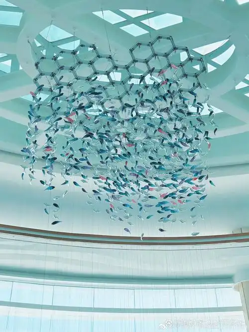 天花板悬挂着五彩斑斓的小鱼装置艺术,透明或半透明的小鱼轻盈摇曳