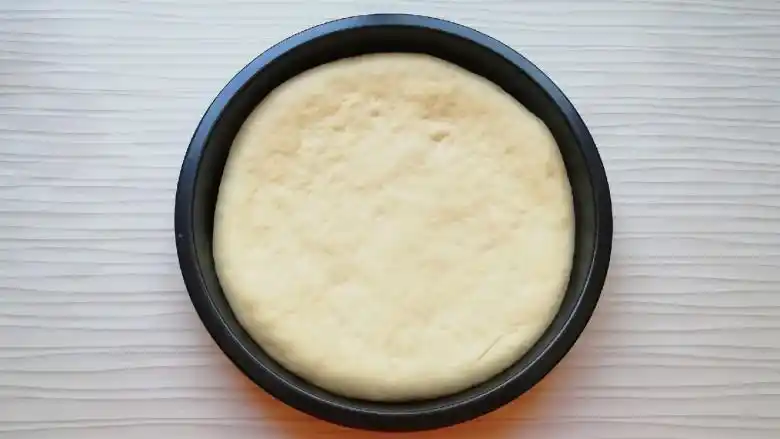 火腿彩蔬披萨,发酵好的面团揉光排气,擀成和披萨盘一般大小的面饼