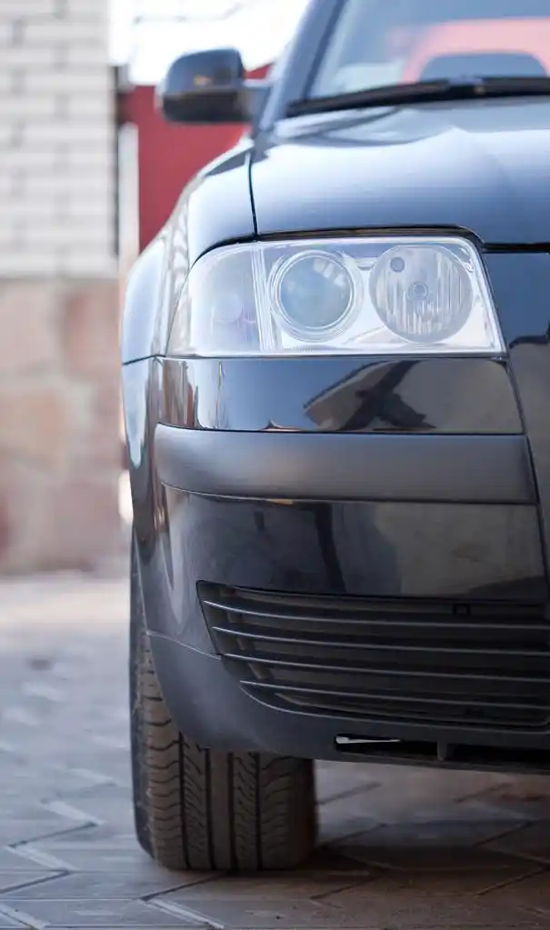 汽车的前灯,一辆黑色的轿车前照灯的特写照片