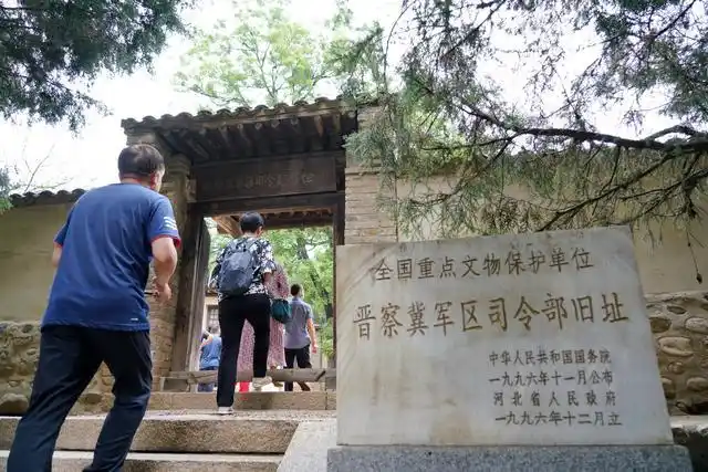 6月13日,参观者进入河北省阜平县城南庄镇晋察冀军区司令部旧址.