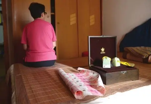 9月13日,长勘小区,金云柳(化名)家的床上放着她买的玉器和银行纪念