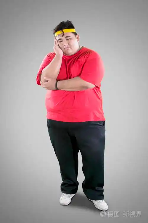 年轻的胖子在演播室锻炼后看起来很累