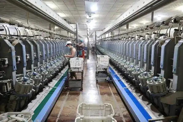 7月20日,工人在河北省滦南县长凝镇的一家纺织厂生产车间里工作.