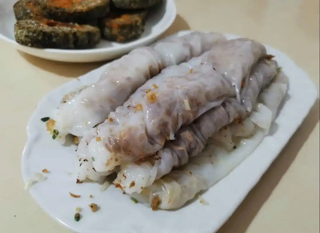 自制的米浆摊在铺着纱布的蒸锅上蒸熟,得到了一张细弹软滑的卷粉皮,再