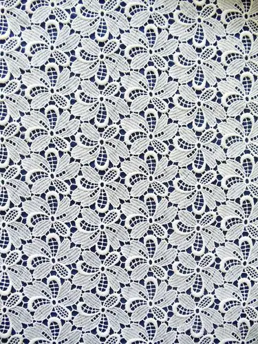 白色蕾丝面料与暗蓝色背景上的花卉图案