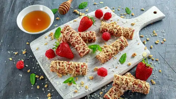 格兰诺拉燕麦卷与草莓, 覆盆子蜂蜜和白巧克力在砧板上