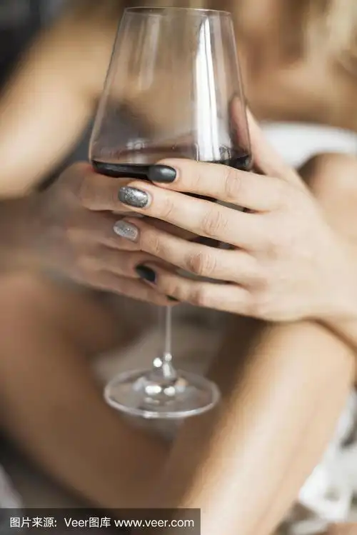 女人的手拿着红酒杯