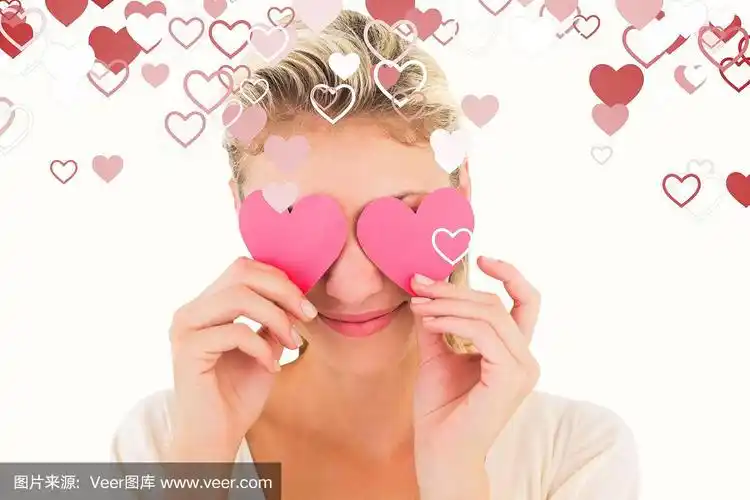 迷人的年轻金发碧眼手捧心形的合成图像