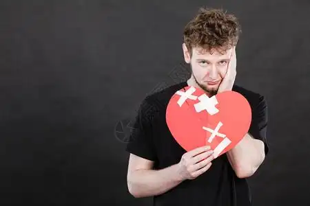 非常悲伤的年轻男子心碎的是纸做图片素材