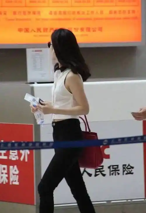 现身机场的她穿着白色露脐装搭配黑色长裤,露出瘦而不柴的手臂线条