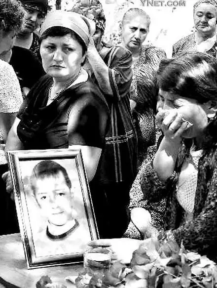 国别斯兰市第一学校的人质事件中遇难儿童的亲人手持其照片哭泣不止