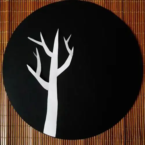 并用白色素描纸剪出树干,先在黑色卡纸上摆位置,(只是摆位置,先不固定