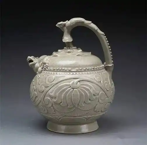 3,五代耀州窑青釉刻花提梁倒流壶碗为直口深腹,外壁饰浮雕莲花三组,盏