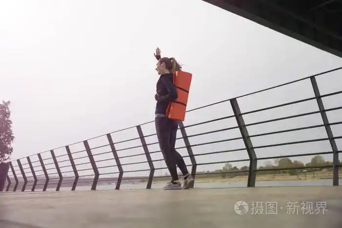 健身妇女背着垫子走路