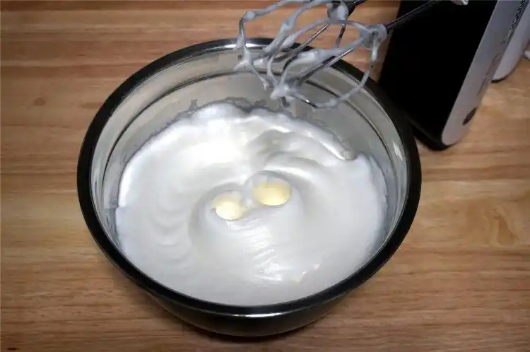 5个蛋清中滴入4滴柠檬汁,分3次加入60克细砂糖,中速打发蛋清,至硬性