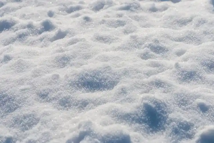 白色雪地铺满地面有灯光和阴影的新雪,特写