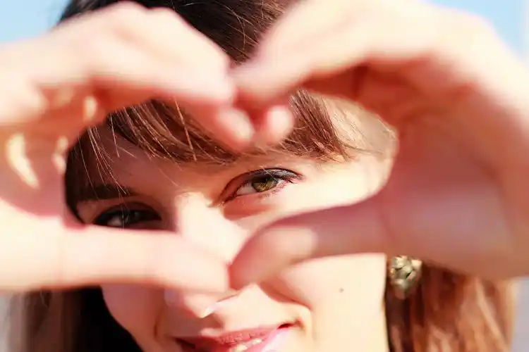 女孩做比心的手势美丽的女孩秀爱标志