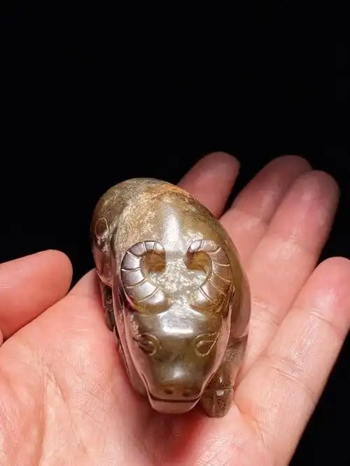 1克 此件卧牛以和阗玉籽料琢制而成,玉质细腻,光气浑厚,局部受褐色沁