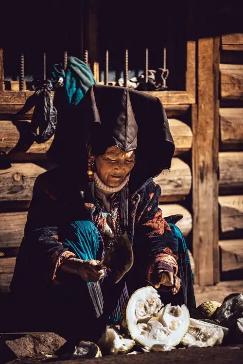 路边的彝族大妈切着当地"南瓜"(猪食)前去派了根烟,知道我要给她拍照