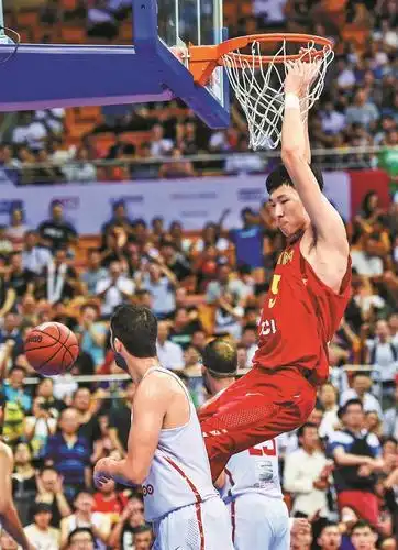 中国男篮红队球员周琦(上)在比赛中扣篮.