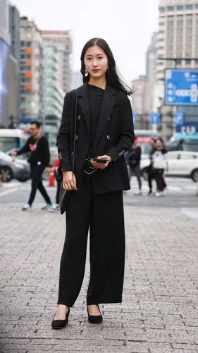 美女一身黑色套装,阔腿裤有一丝飘逸感,整体穿出了黑色的高级感.