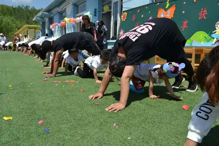 全园幼儿和家长共同参与的一个大型亲子游戏"钻山洞".