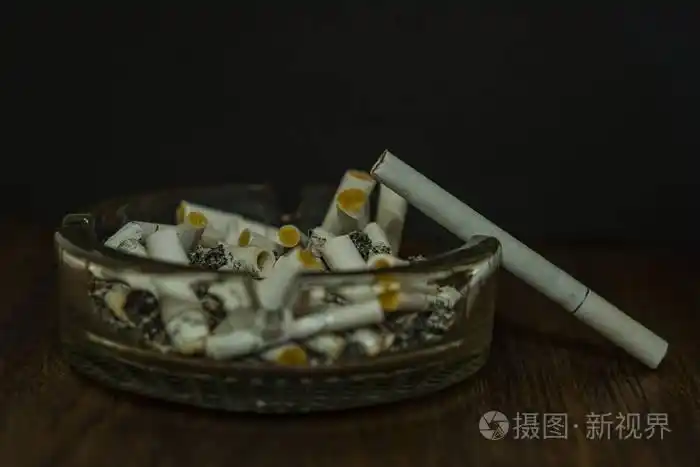照片 烟头在一个玻璃烟灰缸.一支烟不亮.jpg