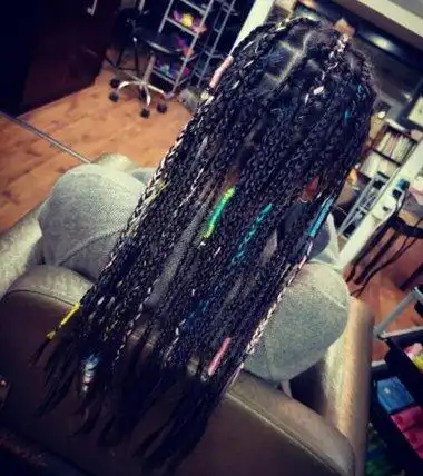 女生后梳长发非洲辫发型,满头的小辫子只有几缕添加了彩色丝线.