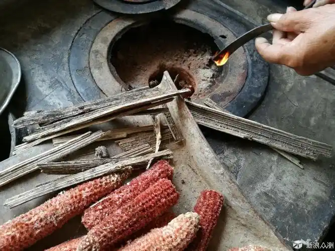 (奶奶在用玉米棒生火)