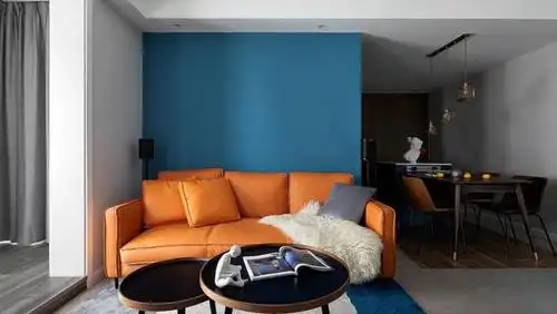沙发选择了橙色皮质款式,背景墙用蓝色来装饰,两者的对比更突显出橙色