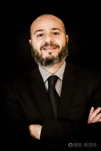 英俊秃顶男人留着胡子在西装和领带在黑色的背景和目标