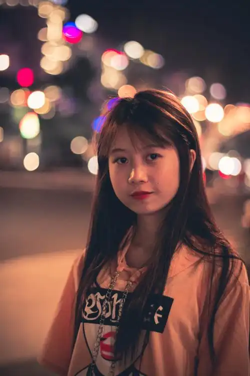 黑色和红色印花套头连帽衫的女人,晚上站在路边拍照|人物,可爱的,夜晚