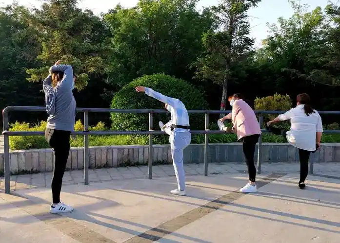 外地来京的年轻姑娘们压腿锻炼.