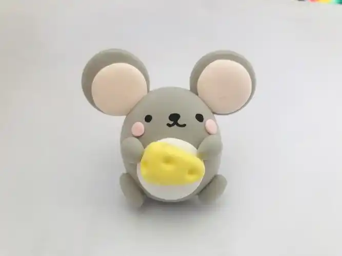 用黄色粘土做一块三角形的奶酪放到小老鼠手里,爱吃奶酪的小老鼠就